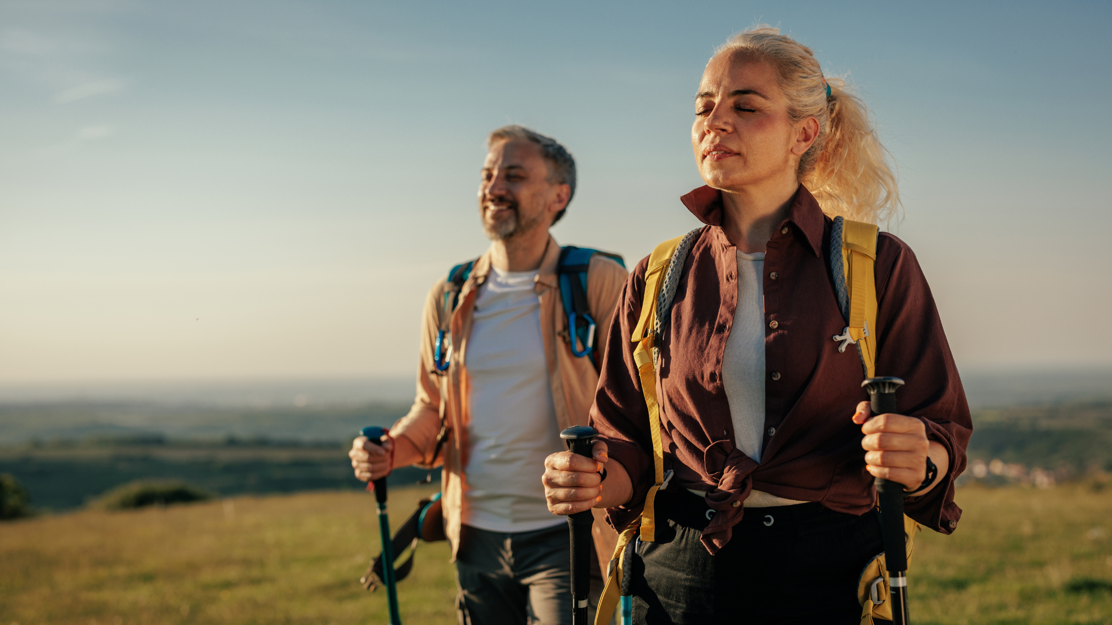 Woman and man enjoying the sun's warmth while on a hike.